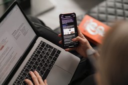 Person multitasking with a laptop and a phone