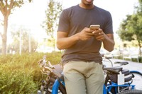 Person checking their phone outdoors, symbolizing the accessibility of client updates and notifications through mobile apps.